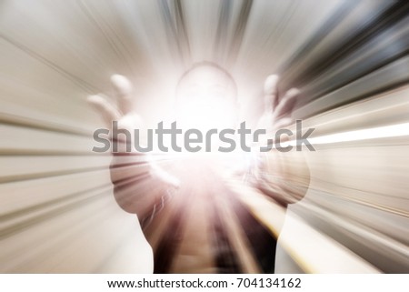 A man holding out his hand with an explosive shining light for the concept: Presenting a shining example. Royalty-Free Stock Photo #704134162