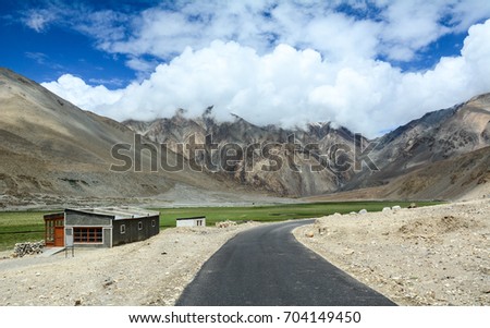 Mountain road with a small house in Ladakh, India. Ladakh is a barren yet beautiful region located in the north Indian state of Jammu and Kashmir.