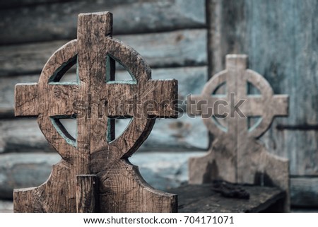 Old Gothic style and roughly carved wooden bench with a very old cross symbol as gable