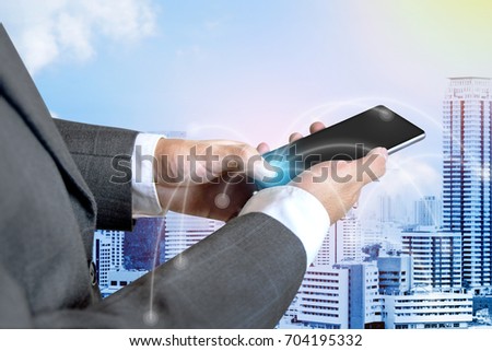 Closeup of Business man touch social network structure of Digital composite on smartphone with building in the city background.