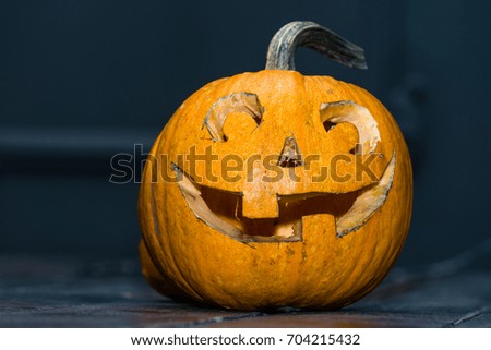 Halloween pumpkin head jack lantern on dark wooden background. Concept of a holiday Halloween