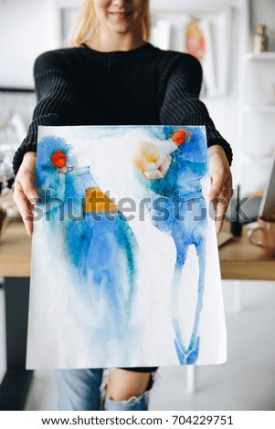 cropped shot of smiling young fashion designer holding watercolor sketch