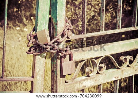 Green metal gate closed with padlock - concept image - little vignette added