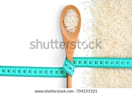 Diet! Lose weight! Wooden spoon with tape measure and raw parboiled rice on white background. Copy space for your text. Close up, top view, high resolution product. Healthy food concept