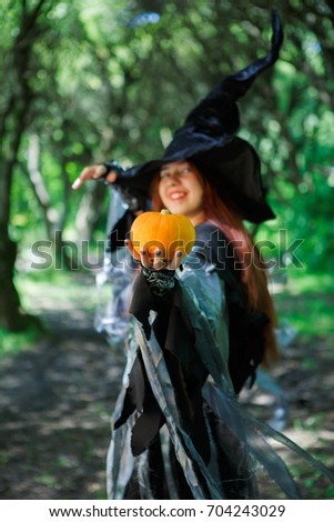 Portrait of witch in hat with pumpkin