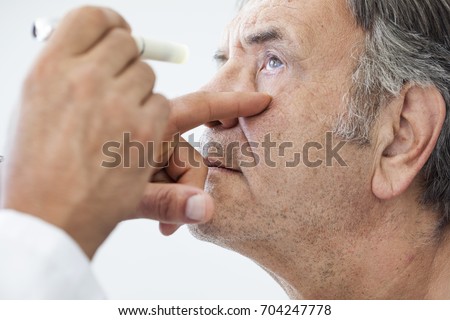 Elderly man examined by an ophthalmologist Royalty-Free Stock Photo #704247778
