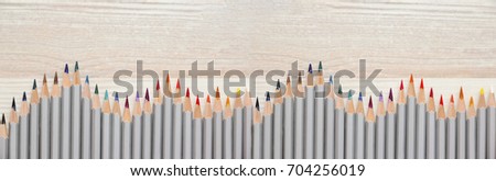 Large background or banner with Multicolored pencils lie on a light wooden table. Beautiful tools for drawing. Knowledge Day design concept. Beautiful tools for drawing. Flat Lay.