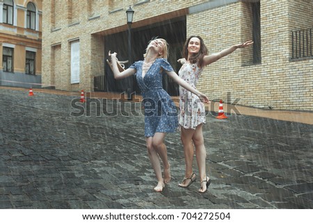 Women are happy with the rain, they are happy and dancing in the rain. Royalty-Free Stock Photo #704272504