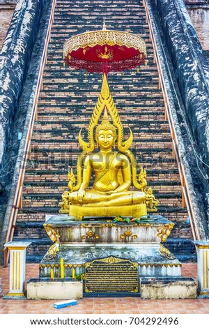 Golden image of Buddha against the background of the staircase leading to the sanctuary of the temple Wat Chedi Luang in Chiang Mai (Thailand)