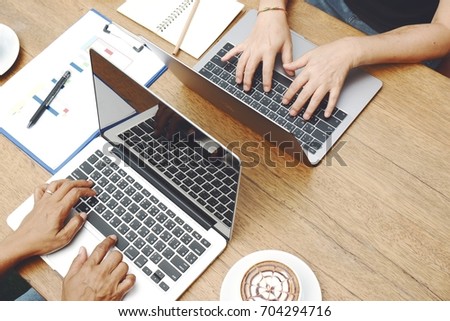Work together with laptop and drinking coffee,Hand typing on laptop keyboard with coffee cup , using computer with hand typing on keyboard
