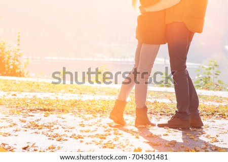 Low section of couple standing in park during autumn