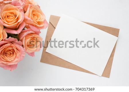 Mockup with postcard and pink roses on white background. card and pink flowers. ink pen, ink, stamp, perfume and ribbon