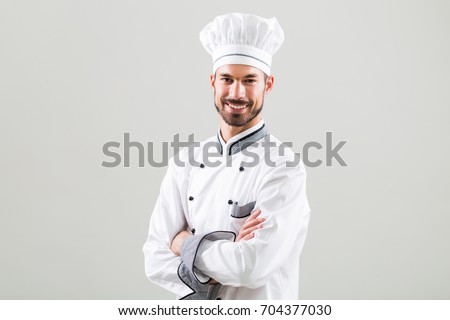 Portrait of smiling chef on gray background.Satisfied chef Royalty-Free Stock Photo #704377030