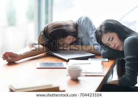 Tired and sleepy business woman closing eyes laying on laptop.Overtime hours concept.