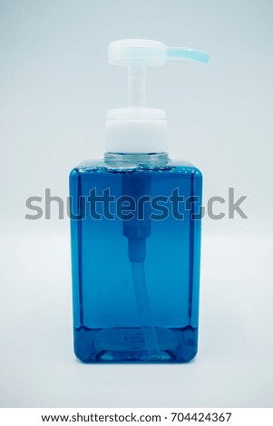 Side View. Blue dish cleansing agent in a clear bottle. Washing agent dispenser. Bubble inside the bottle. 