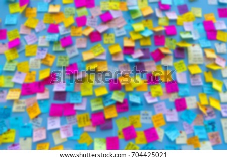 Defocused picture of paper stickers on a office wall, business background