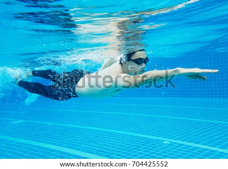 Swimmer young man swimming in the pool and sportsman actives and strong in the pool.
Swimming underwater photo, Sport and Healthy concept. 