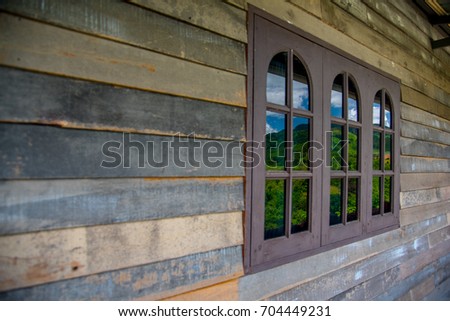 Old wooden plank wall and window pattern. Antique rough and rustic wall of rural house.