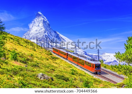 Zermatt, Switzerland. Gornergrat tourist train with Matterhorn mountain in the background. Valais region. Royalty-Free Stock Photo #704449366