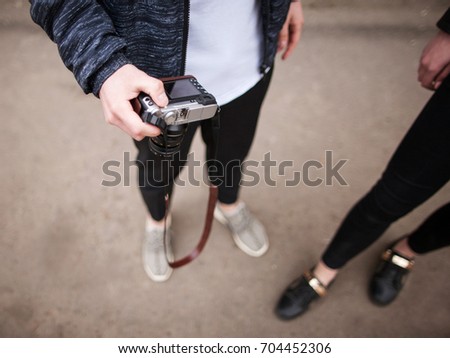 Street photo shoot. Photographers in process. Unrecognizable stylish young people in selective focus, creative lifestyle top view. Modern electronics