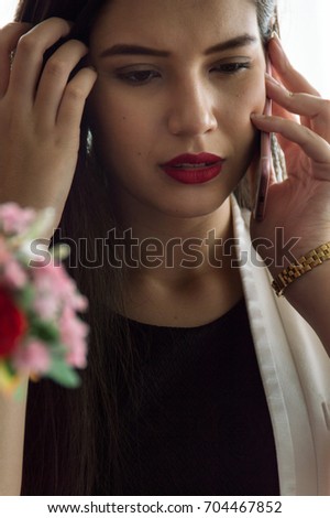 Pretty business woman is talking on the phone. With the anxiety of the information received on the phone.