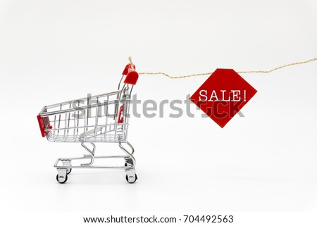 concept of shopping, trolley and there is a rope hanging paper with the words "SALE!".