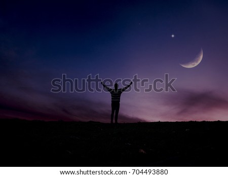 man rising hands under the moon  / soft focus picture

