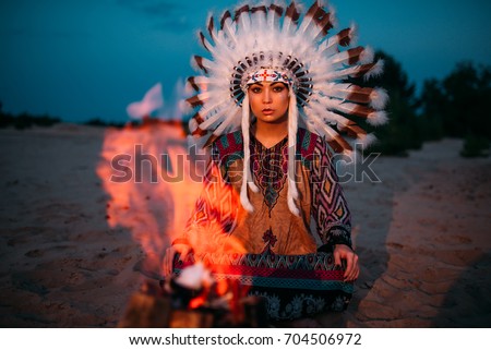 American Indian girl against bonfire, shaman
