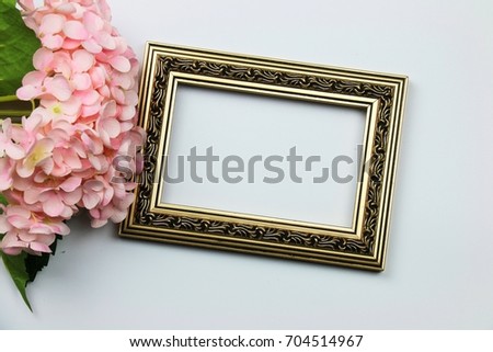 Top view on Blank vintage gold wood frame with branch pink Hydrangea on white background for space idea design