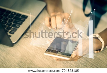 Augmented reality (AR) financial charts showing growing revenue floating above digital  screen smart phone,  businesswoman having meeting about strategy for growth and success / soft focus picture 