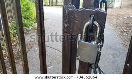 Padlocked iron gate with heavy duty silver fastened lock