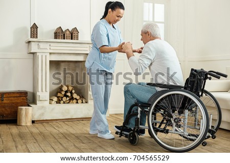 Professional experienced caregiver looking after her patient