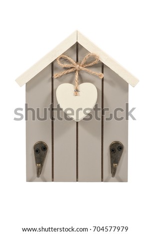 Decorative little house with a heart on a bow of twine and hooks for keys isolated on a white background