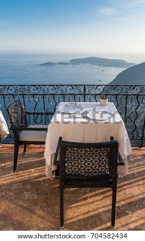 Empty dining table with stunning views overlooking the French Riveira on a sunny day