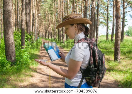 young girl studying map in the forest, walking in nature, concept of tourism and camping