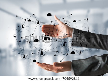 Business woman in suit keeping black social media network structure in hands with office view on background. Mixed media.