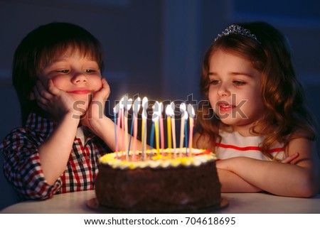 Children's birthday. Children near a birthday cake with candles.