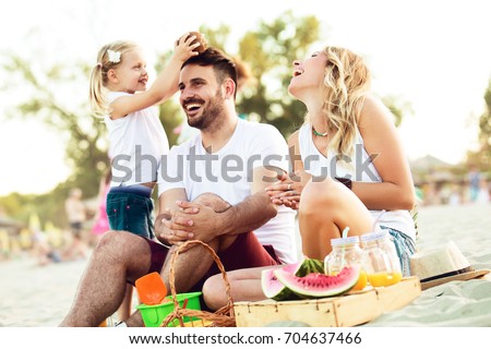 Happy family is enjoying beach and having pic-nic.