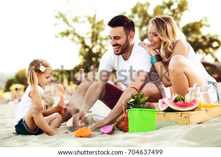 Happy family is enjoying beach and having pic-nic.
