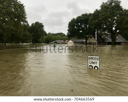 Hurricane Harvey 2017, flooding in Spring Texas, a couple miles north of Houston. Speed limit sign almost completely submerged. Royalty-Free Stock Photo #704663569