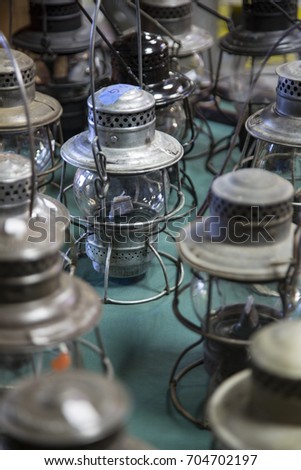 Isolated Vertical View of Antique Kerosene Camping Lanterns on Tabletop
