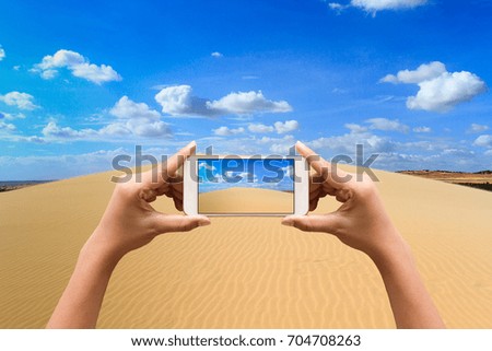 Taking a photos by smartphone of white sand dune with beautiful sky. Landscape.