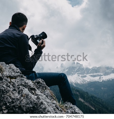 Man traveler with digital camera taking a photo