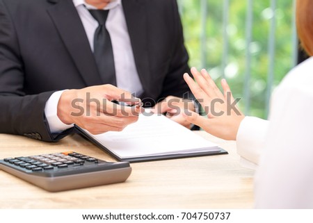Customer or woman says no or hold on when businessman giving pen for signing a contract. Royalty-Free Stock Photo #704750737