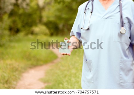 Doctor and nature concept. DOCTOR KEEPING THE PUZZLE IN HANDS. MEDICINE AND TECHNOLOGY. Photo horizontal for your design.