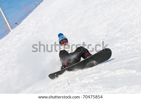 falling young man on snowboard at snowy winter