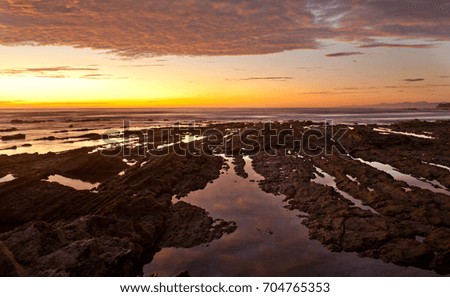 A photo of a series of long tide pools during sunset along the pacific coast of costa rica on the nicoya peninsula.