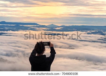 Silhouette of photographer taking picture of landscape during sunset, soft and select focus 
