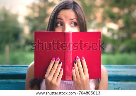 Blurred student girl with red book.