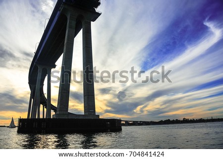 Streaky cirrus clouds paint a golden sky over the Coronado Bay Bridge, San Diego, California
